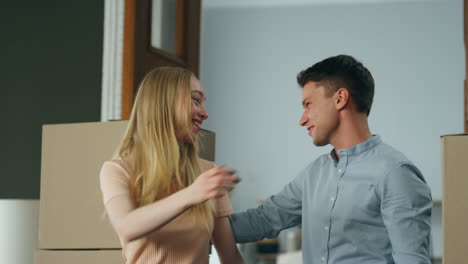 Husband-showing-new-home-to-blond-wife-making-surprise-close-up.-Couple-moving.