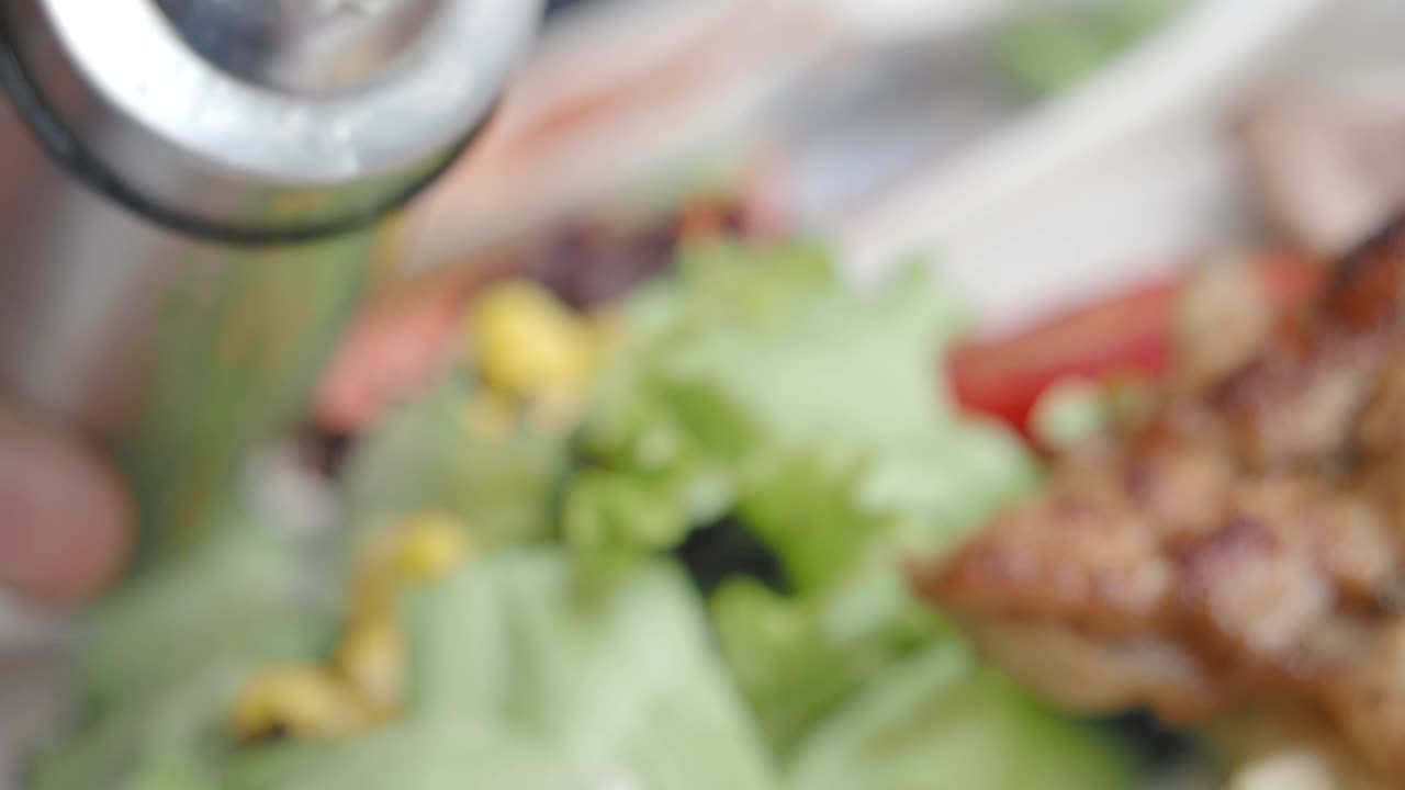 Pouring Olive Oil on a Salad