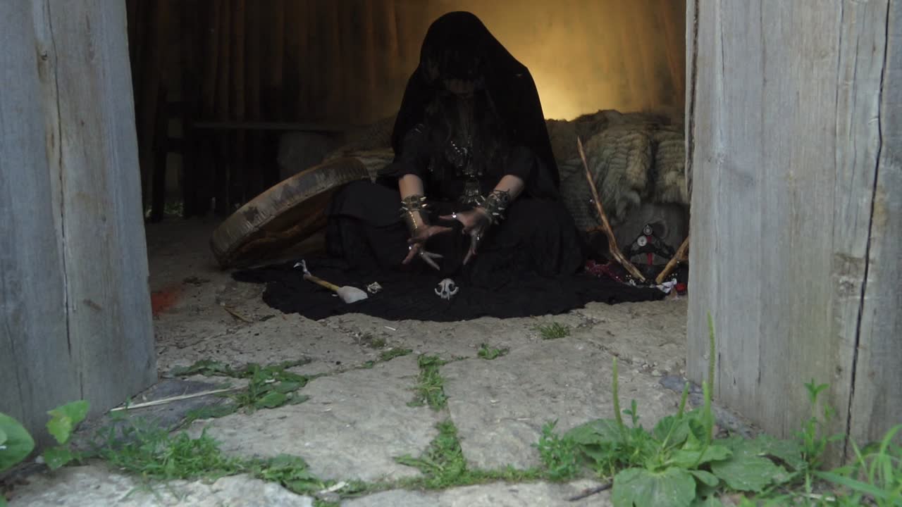 wigwam 안에 앉아 마술을하는 무당