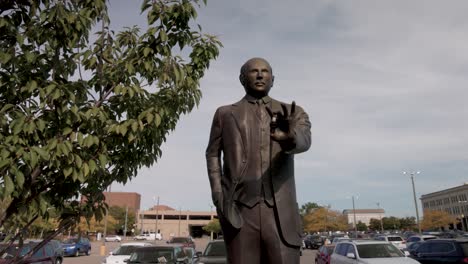 statue of auto pioneer albert champion in flint, michigan with gimbal video moving forward