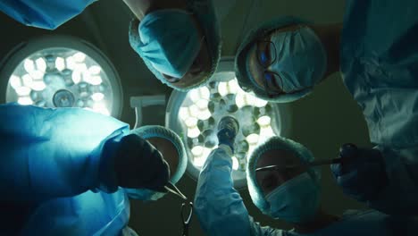 surgeons wearing face masks holding surgical instruments in operating theatre