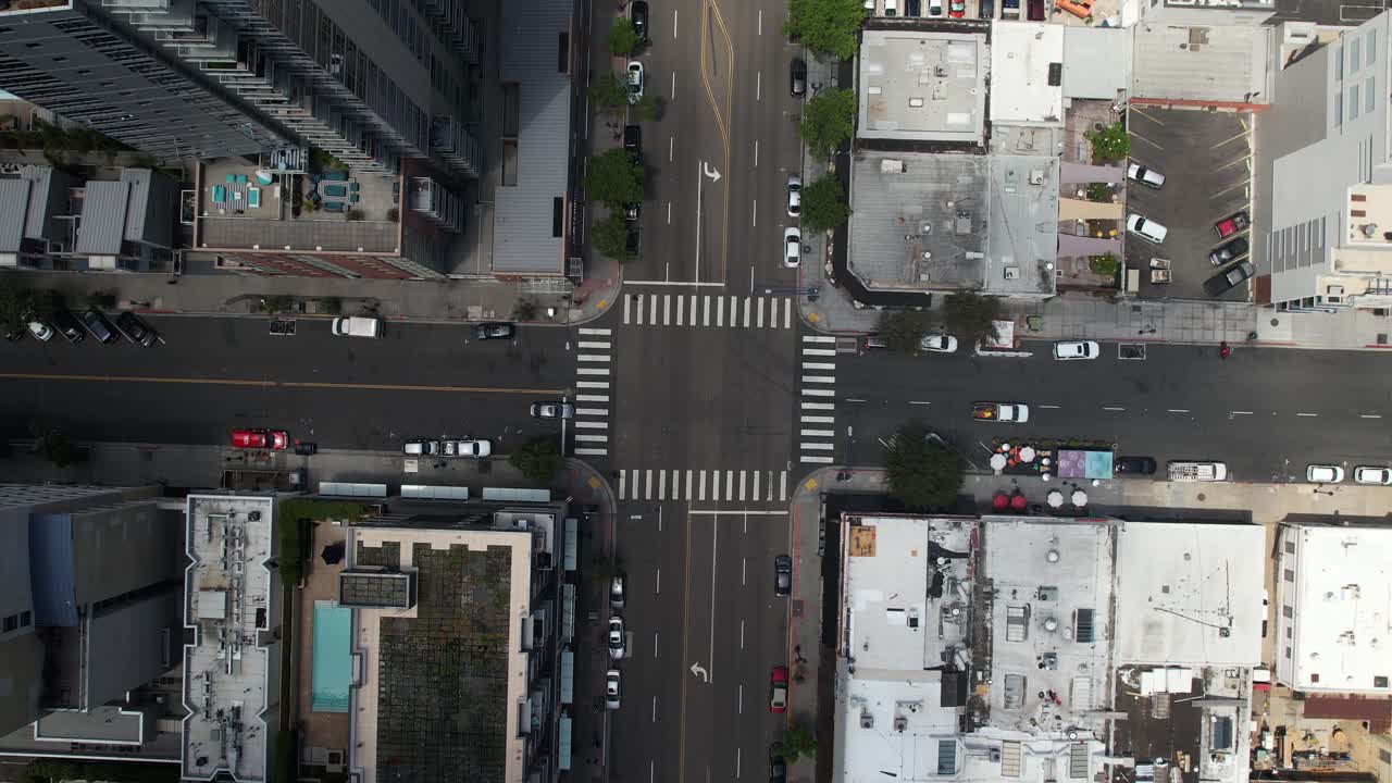 Drone ascending upward while the camera looks down at downtown San Diego buildings and streets, revealing the surrounding urban landscape