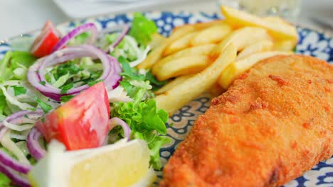 Delicioso-Pescado-Y-Patatas-Fritas-Con-Ensaladas-Frescas-En-El-Restaurante,-De-Cerca