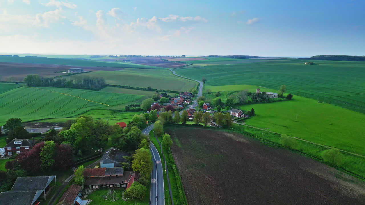 Aerial drone scene captures Burwell village, once a medieval market town, amidst country fields, vintage red brick houses, and the decommissioned Saint Michael parish church on Lincolnshire's Wolds