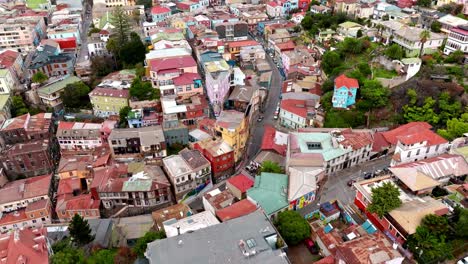 aerial dolly in of colorful neighborhood houses in alegre hill and street that divides it from concepcion hill, valparaíso, chile