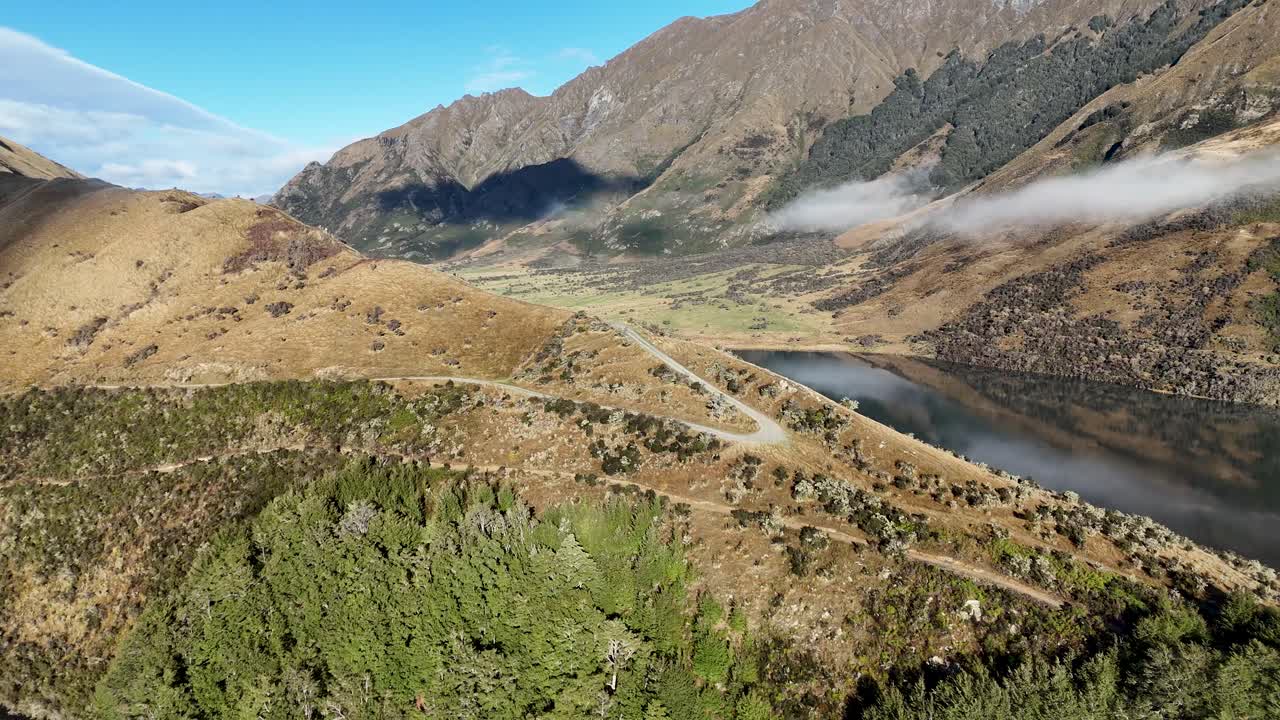 Aerial footage captures Lake Moke's serene landscape in Queenstown, New Zealand, with sweeping views of mountains and lush greenery