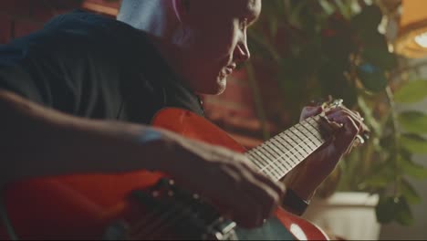 man playing a red electric guitar