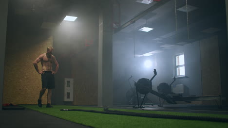 tired man after training with ropes rests in the training hall in slow motion