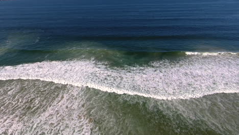 vista aérea de drones del océano con olas rompiendo y tiro de arena en 4k de alta resolución