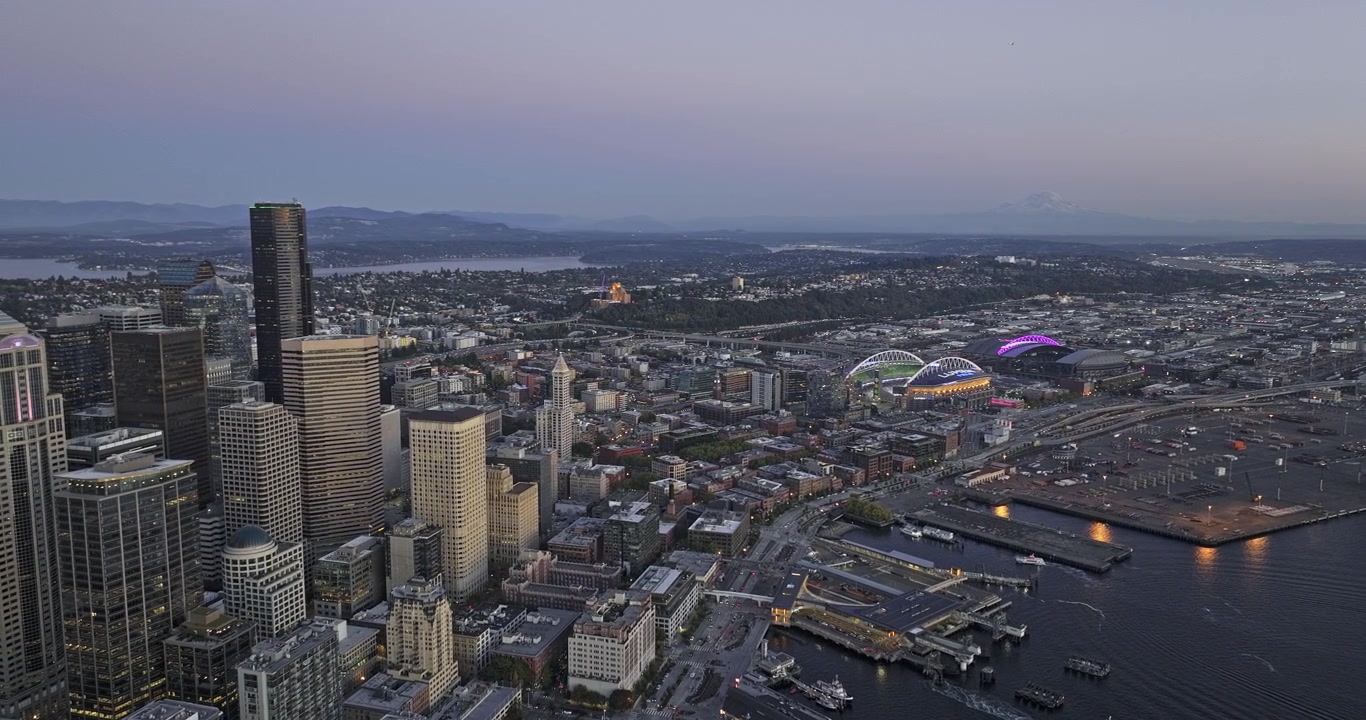 Seattle Washington Ilmakuva v191 hämärän ylilento keskustan, rannan lauttaterminaalien ja Elliott Bayn yllä kohti Sodoa, Beacon Hilliä ja vuoria – Kuvattu Mavic 3 Pro Cine -kameralla – 6. lokakuuta 2023.