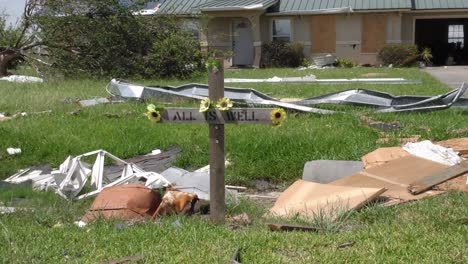 Una-Cruz-Decora-Un-Césped-Rural-Cubierto-De-Escombros-De-Casas-Dañadas-Por-Un-Tornado-De-Viento-Fuerte-En-Iowa