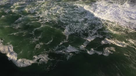 tiro cinemático inclinado hacia arriba del océano agitado con grandes olas y rocas