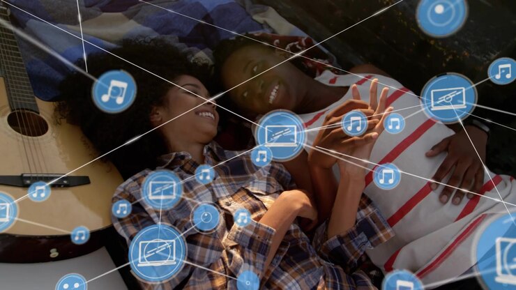 Couple on quilt, woman tapping phone sharing music mail icons expanding into network over couple