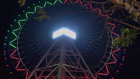 lapso de tiempo de una rueda grande dando vueltas iluminada con luces cambiantes de colores en la noche