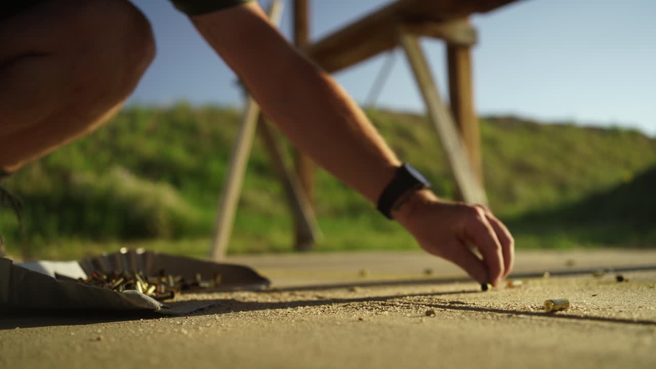 낮은 각도 시야: 사람들이  ⁇ 을  ⁇ 고, 사용된 권총 탄두를 수집합니다.
