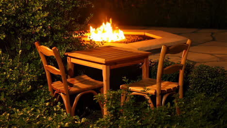 cozy outdoor seating area with a lit fire pit at night