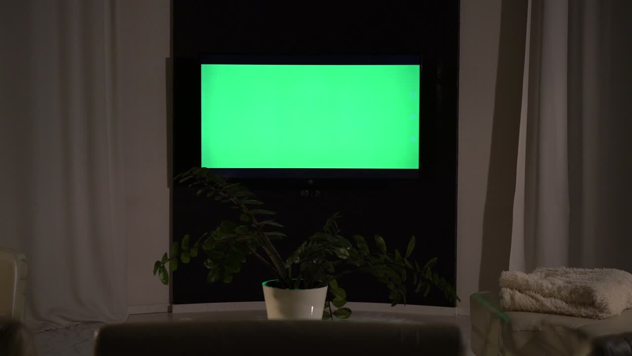 A computer with a green screen stands on the table