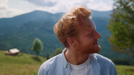 Closeup-redhair-man-enjoying-summer-holiday-in-mountains.-Portrait-of-happy-guy.