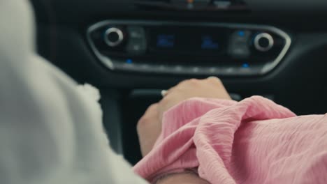 woman starts to hold her boyfriends hand while driving in modern car