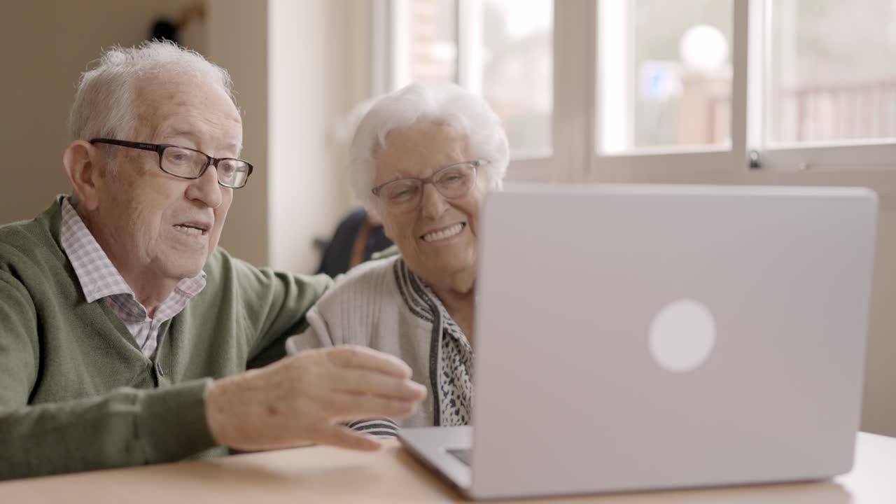 Senior people talking during online meeting using laptop in geriatric