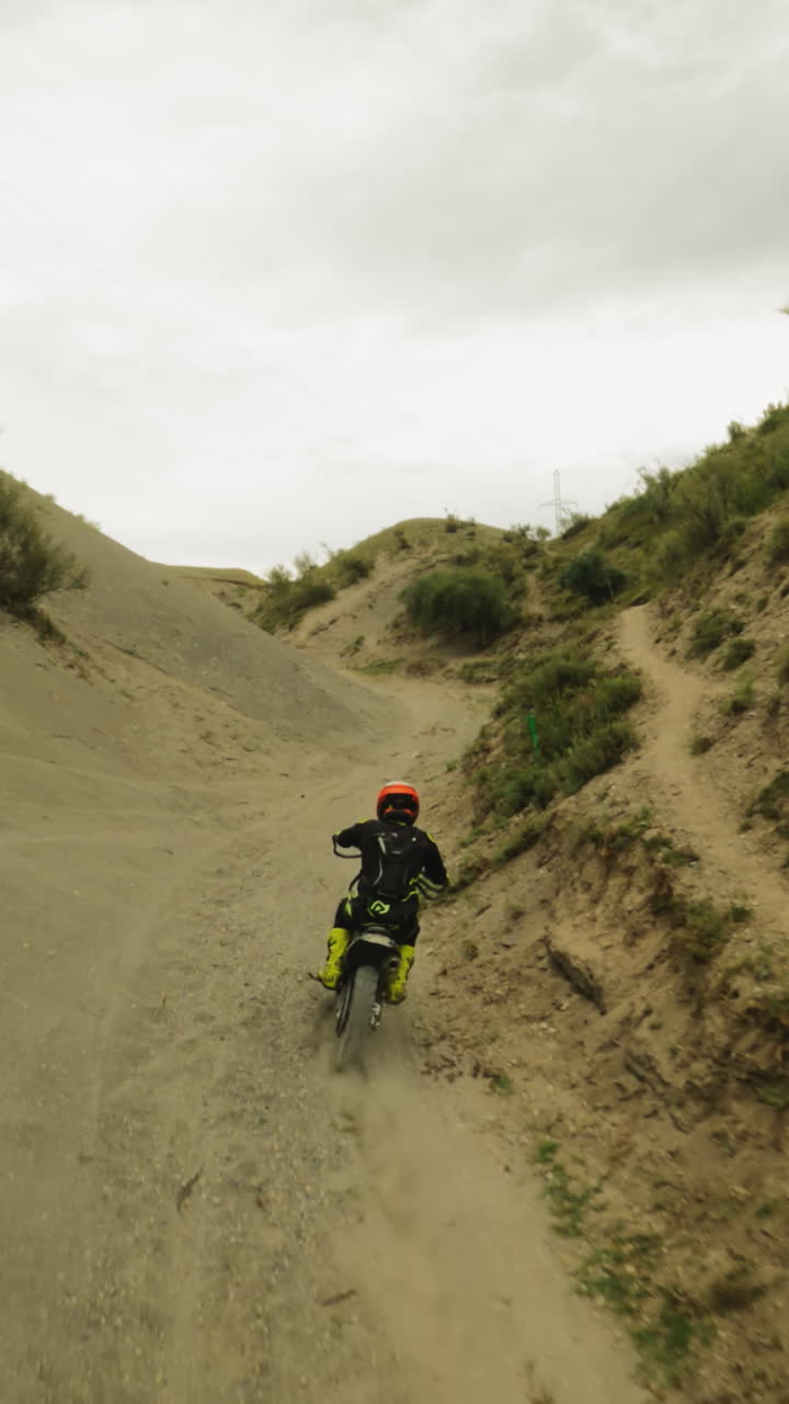 piloto experto conduce el vehículo a lo largo del hueco entre las colinas fpv motociclista en offroad trenes de motocicleta para carreras de motocross motociclismo en el desierto