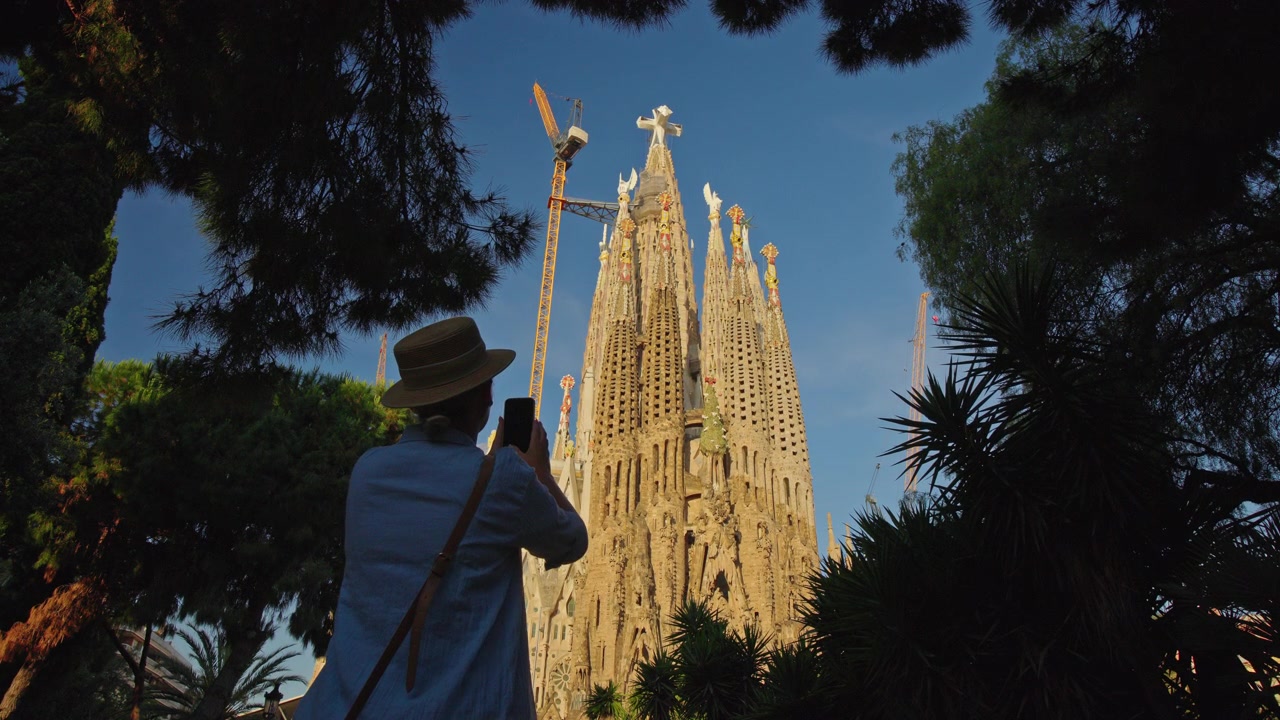 Viaggiatore che fotografa la Sagrada Familia con lo smartphone a Barcellona