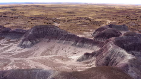 drone flying forward over a dusty badland on a sunny day