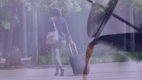 composite video of tea pouring out of kettle against businesswoman with trolley bag walking