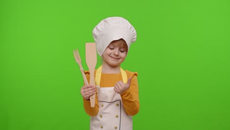 Child-girl-cook-chef-baker-in-apron-and-hat-smiling,-nods-head-in-agreement-on-chroma-key-background