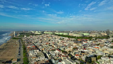 Vista-Aérea-Sobre-El-Barrio-De-Manhattan-Beach-En-California-Con-Torres-De-Tratamiento-De-Agua-Al-Fondo