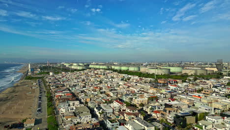 aerial view over the manhattan beach neighborhood in california with water treatment towers in the background