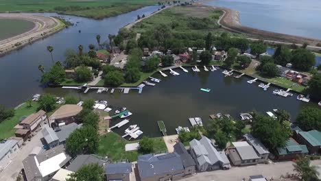 aerial drone video of riverside neighborhood with boats and canals