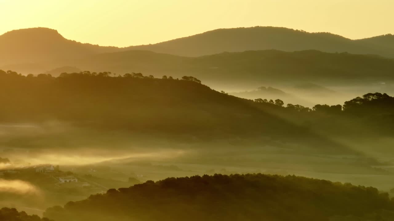 공중 은 이리적인 안개가 신비로운 마을을 가로질러 퍼져 있고, 빛은 계곡을 가로지르고 있습니다.