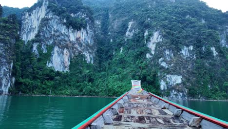 Vista-Desde-El-Interior-De-Un-Pequeño-Barco-Navegando-Por-Las-Aguas-Del-Lago-Cheow-Lan,-Un-Vasto-Embalse-Rodeado-De-Acantilados-Verticales-De-Piedra-Caliza-Y-Exuberante-Vegetación,-En-El-Parque-Nacional-Khao-Sok,-Surat-Thani,-Tailandia