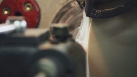 close up grinding the shaft on the machine with sparks and cooling