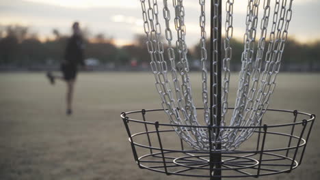 golfista de disco falla el putt para birdie al golpear la jaula de la canasta de golf de disco