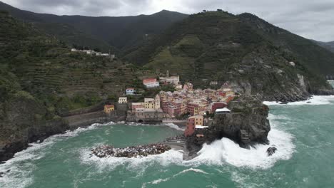 ORBITAL-AIREAL-DRONE-SHOT-LEFT-TO-RIGHT-OF-CINQUE-TERRE-ITALIAN-VILLAGE-TOWN-BY-THE-BEACH-WAVES-CRASHING-HIGH-ANGLE