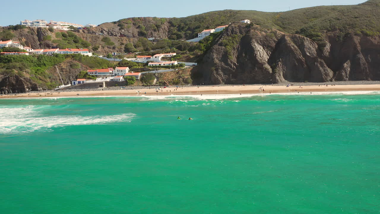 antena: el pueblo de arrifana con gente surfeando