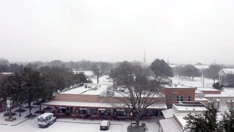 small town shopping center being covered with white snow