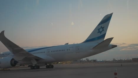 Jüdisches-Flugzeug-Mit-Israelischer-Flagge,-Das-Mit-Dem-Davidstern-Am-Flughafenterminal-Im-Sonnenuntergang-Reist