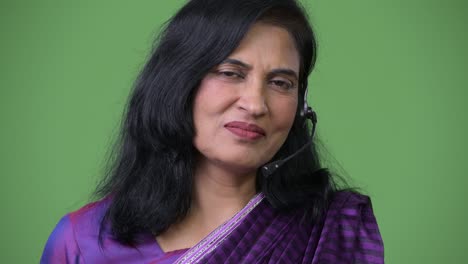 close up shot of mature happy beautiful indian woman as call center representative talking on headset