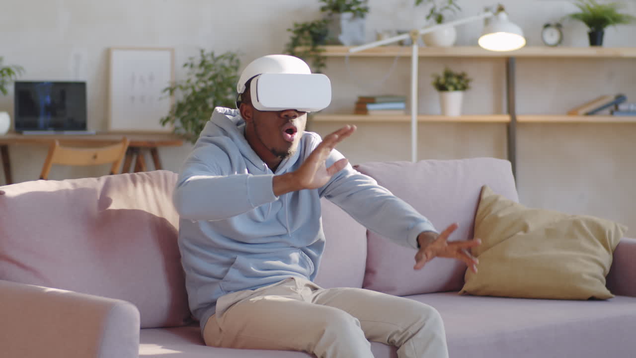Amazed African American Man Using VR Glasses at Home