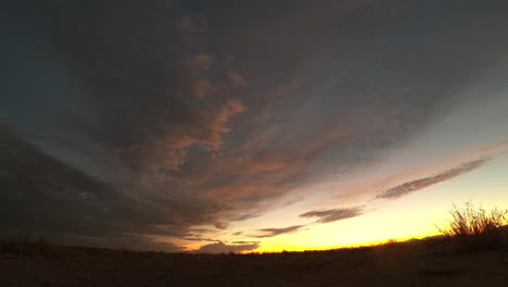 la puesta de sol rosa y dorada se desvanece lentamente en la oscuridad en la llanura del desierto de mojave
