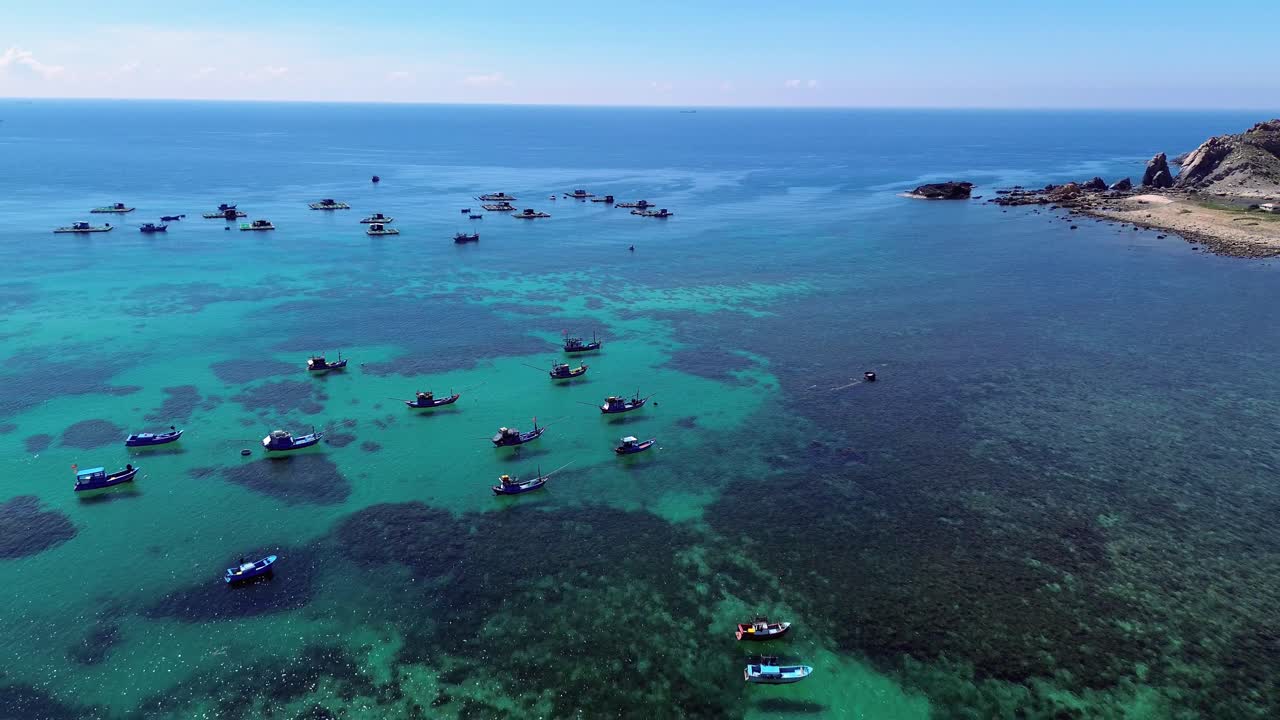 Aerial view of fishing village in Ninh Hải District, Ninh Thuận with smooth zoom out revealing the extensive fishing boats and the stunning turquoise waters. Ninh Hải District, Ninh Thuận, Vietnam
