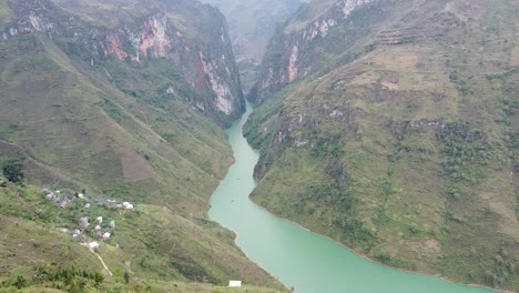 stunning aerial footage of a serene river winding through lush, steep cliffs in vietnam. misty atmosphere enhances the tranquil beauty, showcasing rich greenery and winding waters