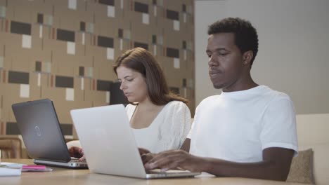 diverse couple of professionals sitting together at table