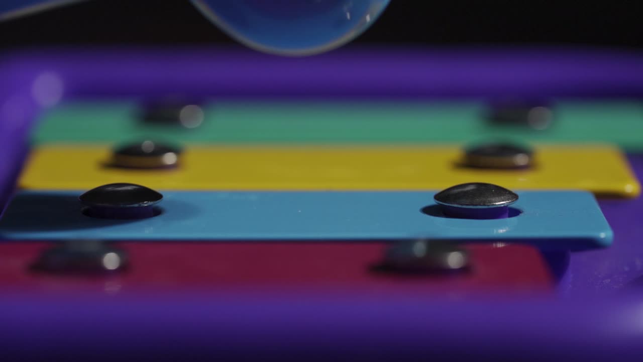 toma macro de un xilófono infantil tocado, instrumento musical en cámara lenta