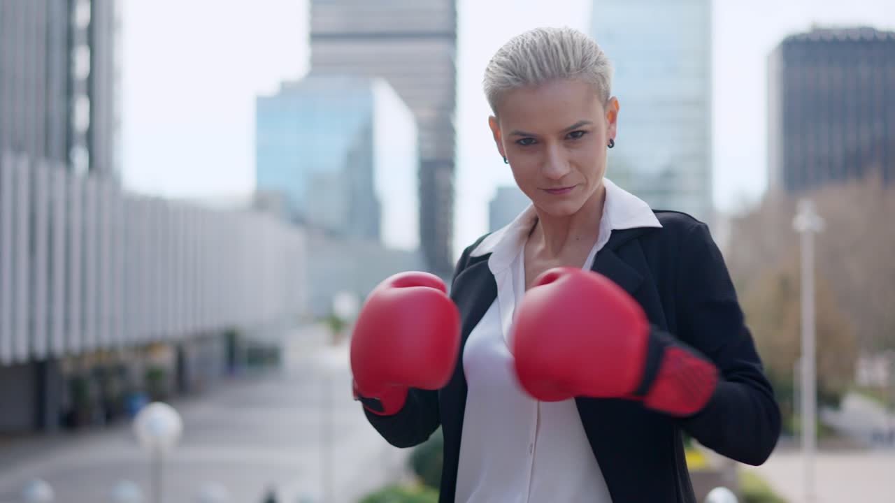 Businesswoman in boxing gloves ready to fight in an urban setting