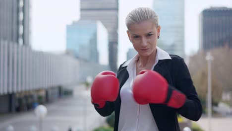businesswoman in boxing gloves ready to fight in an urban setting