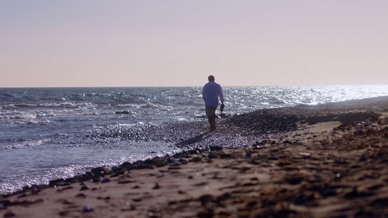 슬로우 모션으로 해변을 걷는 남자